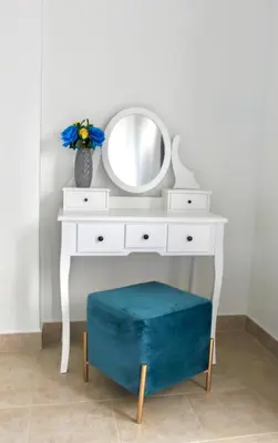 a white dressing table with a mirror and a blue ottoman at Aegiali Sea View Villa in Gennadi