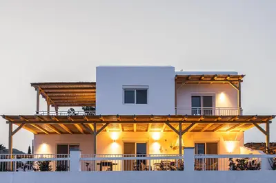 a large white house with a wooden deck at Villa Mamma Mia in Gennadi