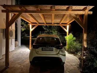 a small car parked under a wooden pergola at Villa Mamma Mia in Gennadi