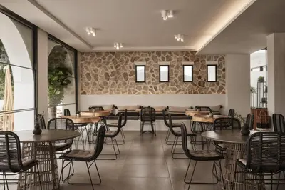 a restaurant with tables and chairs and a wall of windows at Casa Cabana Boutique Hotel & Spa - Adults Only in Faliraki