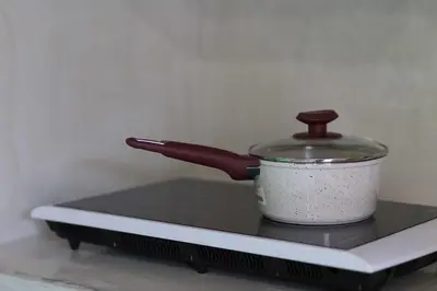 a pot sitting on top of a stove with a pot holder at Hartso - Traditional loft, renovated former forge in Gennadi in Gennadi