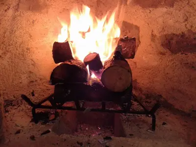 a fire in a brick oven with flames in it at Hartso - Traditional loft, renovated former forge in Gennadi in Gennadi