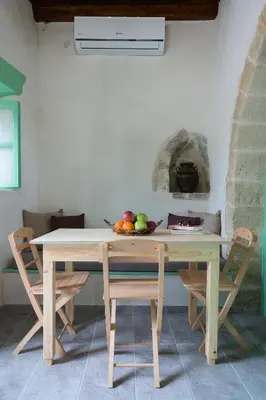 a table with chairs and a bowl of fruit on it at Hartso - Traditional loft, renovated former forge in Gennadi in Gennadi