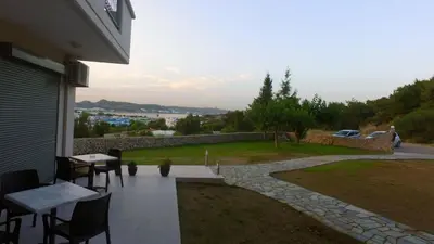 a patio with tables and chairs in a backyard at Miva Sea View in Faliraki
