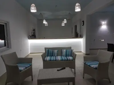 a living room with a couch and chairs and lights at Miva Sea View in Faliraki