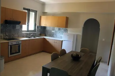 a kitchen with a wooden table and a dining room at Miva Sea View in Faliraki