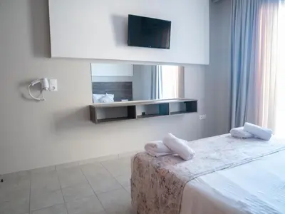 a bedroom with a bed with a tv on the wall at Miva Sea View in Faliraki