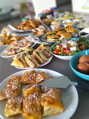 a table full of plates of food on a table at Miva Sea View in Faliraki