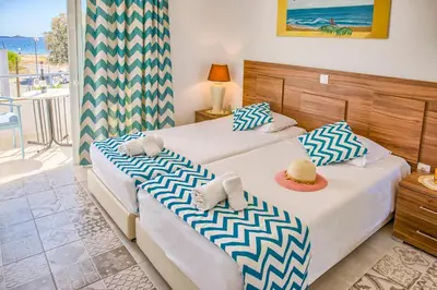 two beds in a room with a balcony at Tommy's Rooms in Haraki
