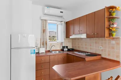 a kitchen with wooden cabinets and a white refrigerator at Tommy's Rooms in Haraki