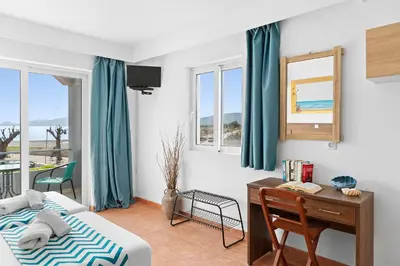a bedroom with a desk and a bed and a desk and window at Tommy's Rooms in Haraki
