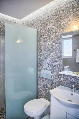 a bathroom with a toilet and a sink at Tommy's Rooms in Haraki