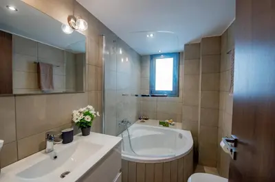 a bathroom with a tub and a sink and a toilet at Villa Oliva Rodos in Ialyssos