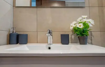 a bathroom sink with a vase of flowers on it at Villa Oliva Rodos in Ialyssos