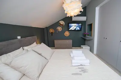 a bedroom with a large bed with white pillows at Villa Oliva Rodos in Ialyssos