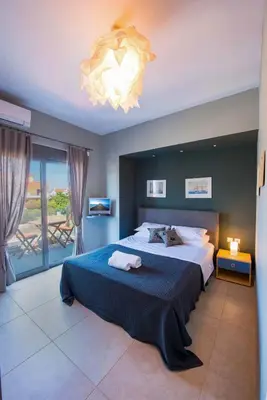 a bedroom with a large bed and a chandelier at Villa Oliva Rodos in Ialyssos