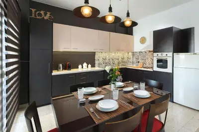 a kitchen with a table and chairs and a white refrigerator at Cozy City Apartment in Rhodes Town