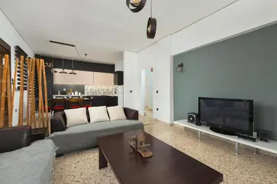 a living room with a couch and a flat screen tv at Cozy City Apartment in Rhodes Town