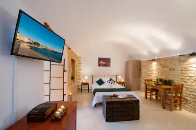 a bedroom with a bed and a tv on a wall at Emerald Dream House in Rhodes Town