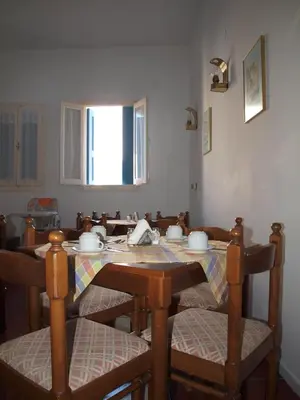 a dining room table and chairs with a table and a window at Horio Village Rooms in Symi