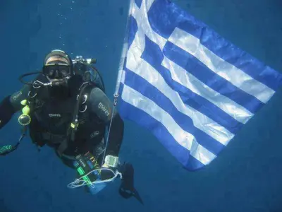 a diver in the water next to a flag at Apollon Apartments H-1 in Rhodes Town