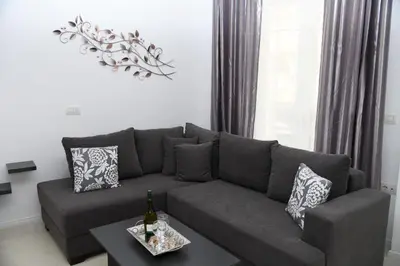 a living room with a gray couch and a table at City Heart Luxury Studios in Rhodes Town