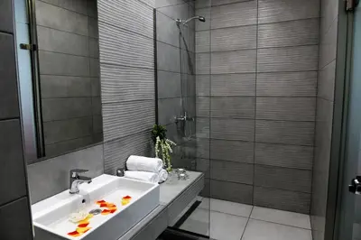 a bathroom with a white sink and a shower at City Heart Luxury Studios in Rhodes Town