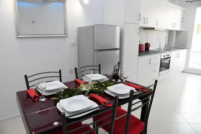 a kitchen with a dining table with chairs and a refrigerator at City Heart Luxury Studios in Rhodes Town