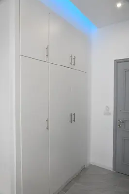 a white room with white cabinets and a door at City Heart Luxury Studios in Rhodes Town