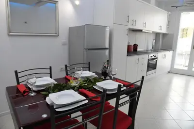a kitchen with a table with chairs and a dining room at City Heart Luxury Studios in Rhodes Town