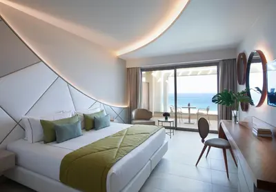 a hotel room with a bed and a view of the ocean at Mayia Exclusive Resort & Spa - Adults Only in Kiotari