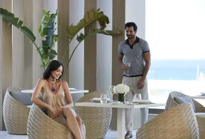 a man and a woman sitting at a table at Mayia Exclusive Resort & Spa - Adults Only in Kiotari