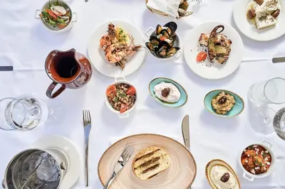 a white table with plates of food on it at Mayia Exclusive Resort & Spa - Adults Only in Kiotari
