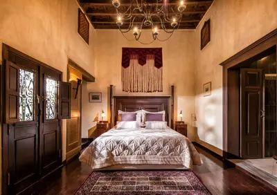 a bedroom with a bed and a chandelier at Lemuria Manor, Wine Dark Sea Villas in Rhodes Town
