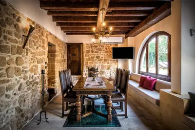 a dining room with a wooden table and chairs at Lemuria Manor, Wine Dark Sea Villas in Rhodes Town