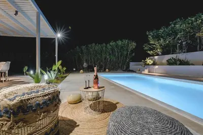 a swimming pool with a bottle of wine next to it at Anssami Villa in Rhodes Town