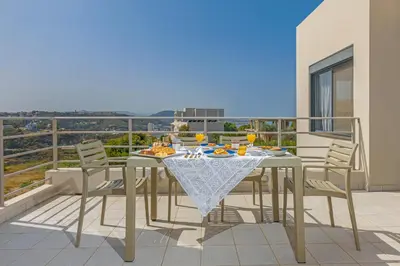 a dining table and chairs on a balcony at Anssami Villa in Rhodes Town
