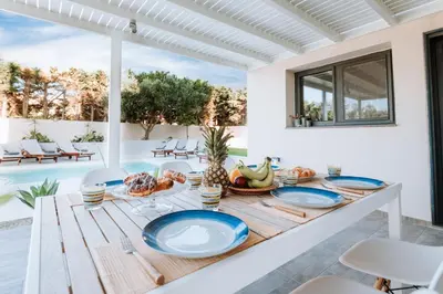 a dining room with a table with blue plates on it at Anssami Villa in Rhodes Town