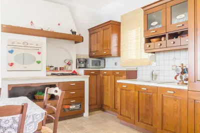a kitchen with wooden cabinets and a stove top oven at Kaya Sea Apts - Stegna Beach in Archangelos