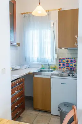 a small kitchen with a sink and a window at Kaya Sea Apts - Stegna Beach in Archangelos