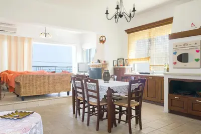 a kitchen and living room with a table and chairs at Kaya Sea Apts - Stegna Beach in Archangelos