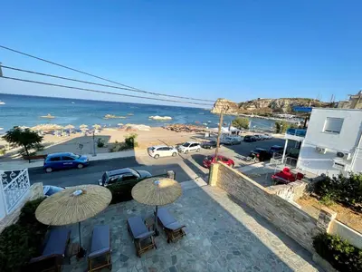 a balcony with umbrellas and a view of a beach at Kaya Sea Apts - Stegna Beach in Archangelos