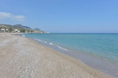 a beach with a rocky shore and the ocean at Sea Spirit in Afantou