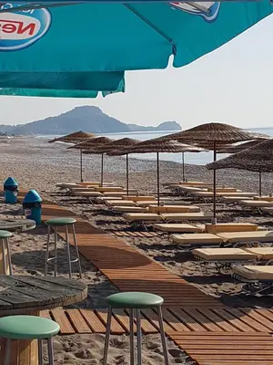 a row of chairs and umbrellas on a beach at Sea Spirit in Afantou