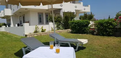 two glasses of orange juice sitting on a table in front of a house at Sea Spirit in Afantou