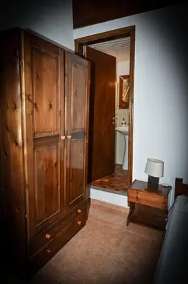 a room with a large wooden cabinet and a lamp on a table at Nymph in Sálakos