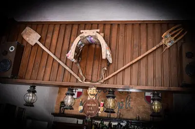 a bar with a wooden wall with various items on it at Nymph in Sálakos