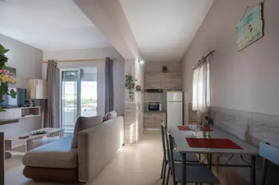 a kitchen and living room with a table and a couch at Stergios top view residence with jacuzzi in Kolimbia