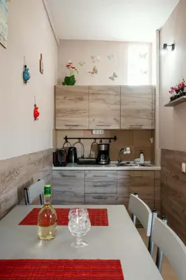 a kitchen with a table with a bottle of alcohol on it at Stergios top view residence with jacuzzi in Kolimbia