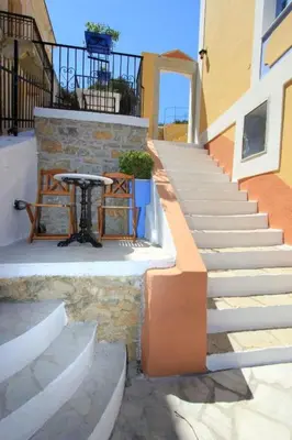 a table on the side of a building with stairs at Dorian Hotel in Symi